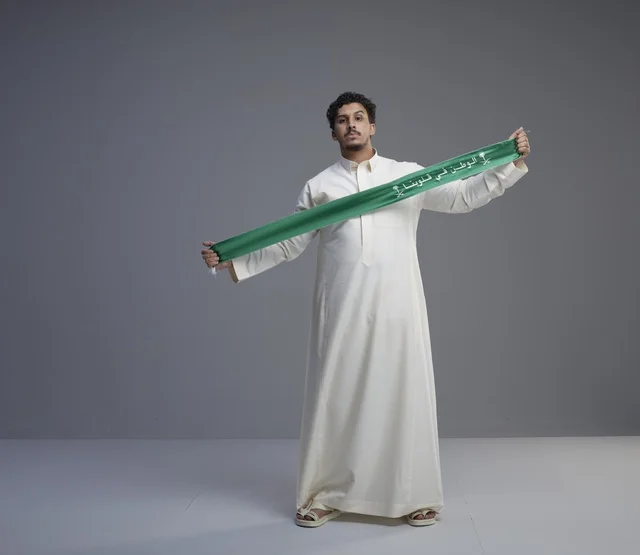 رجل سعودي يحمل وشاح اليوم الوطني في الاستوديو
