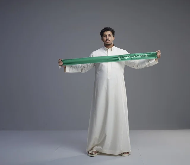 Saudi Man Holding Green National Scarf in Studio