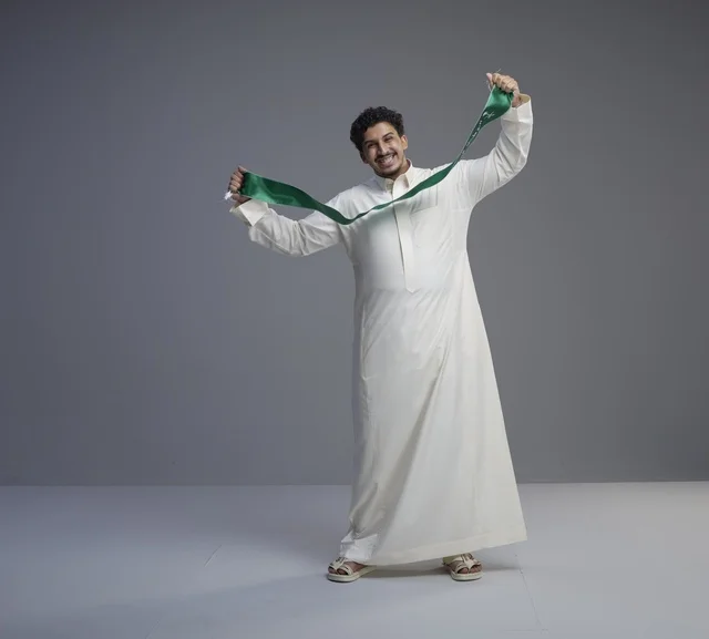 Saudi Man in White Thobe Holding Green National Scarf