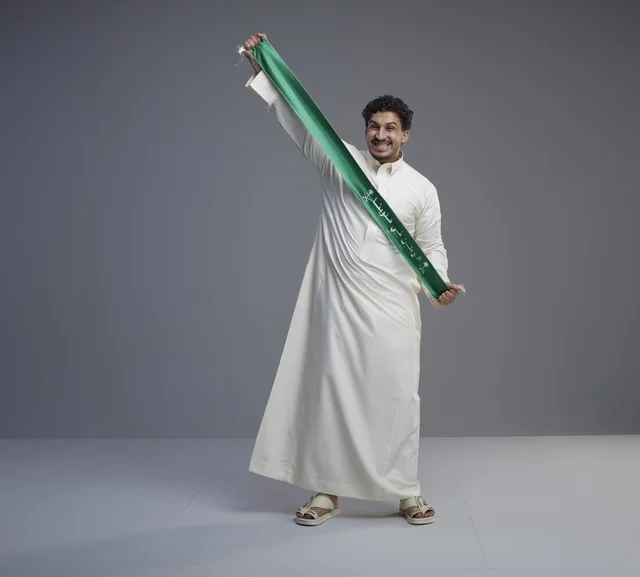 رجل سعودي يحمل وشاح اليوم الوطني في الاستوديو
