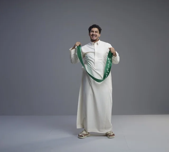 رجل سعودي بالثوب والوشاح الوطني في تصوير استوديو