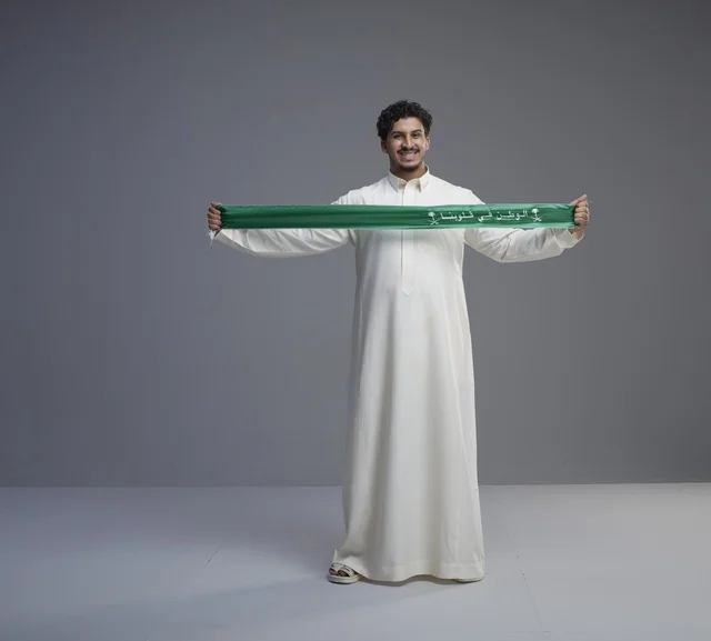 Saudi Man Holding Green National Scarf in Studio