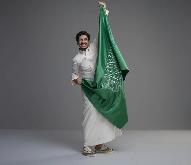 Saudi Man Holding Saudi National Flag in Studio Shot