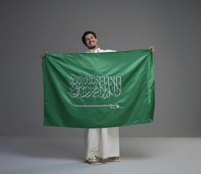رجل سعودي يحمل العلم السعودي في الاستوديو
