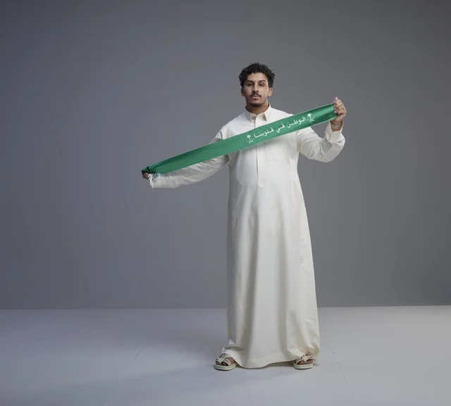 رجل سعودي يحمل وشاح اليوم الوطني في الاستوديو