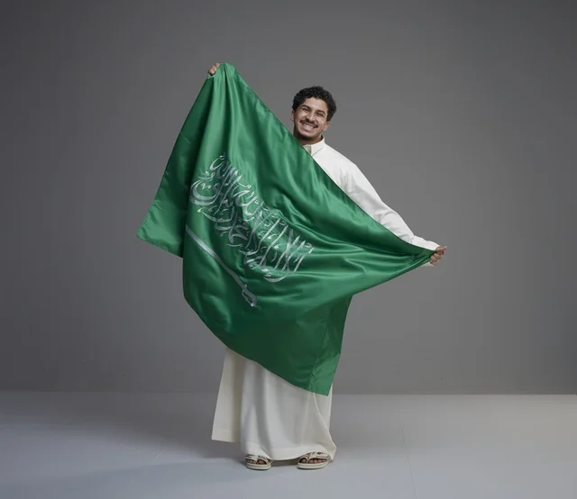 رجل سعودي يحمل العلم السعودي في استوديو