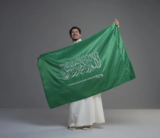 Saudi Man with National Flag on Gray Background