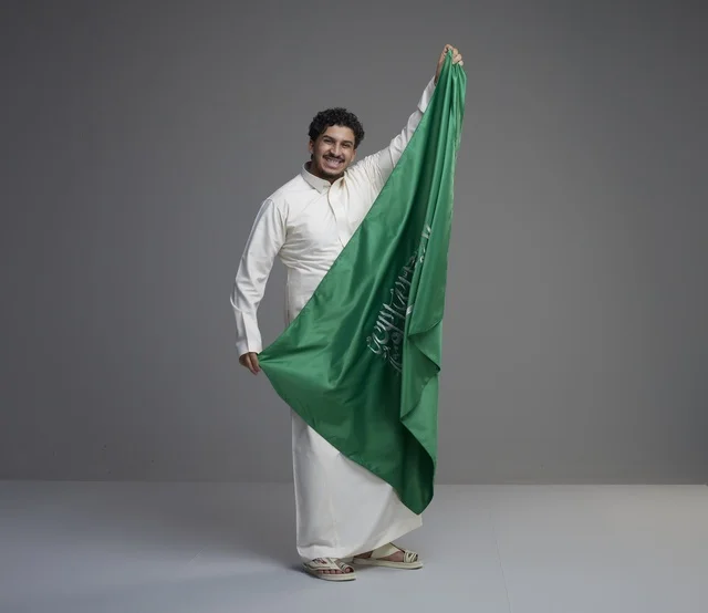 Saudi Man Holding National Flag in Studio