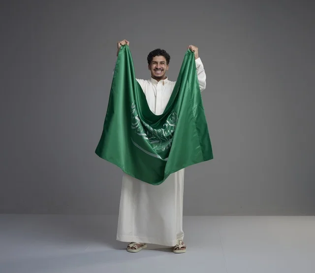 Saudi Man Holding National Flag in Studio Portrait