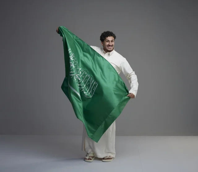 Saudi Man Holding Saudi Arabia National Flag in Studio
