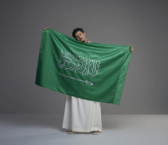 Saudi Man Holding National Flag in Studio