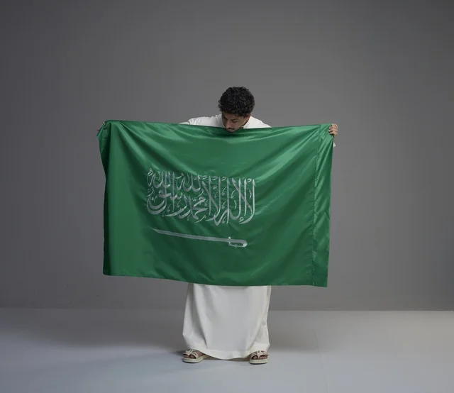 Saudi Man Holding Saudi Arabia National Flag in Studio