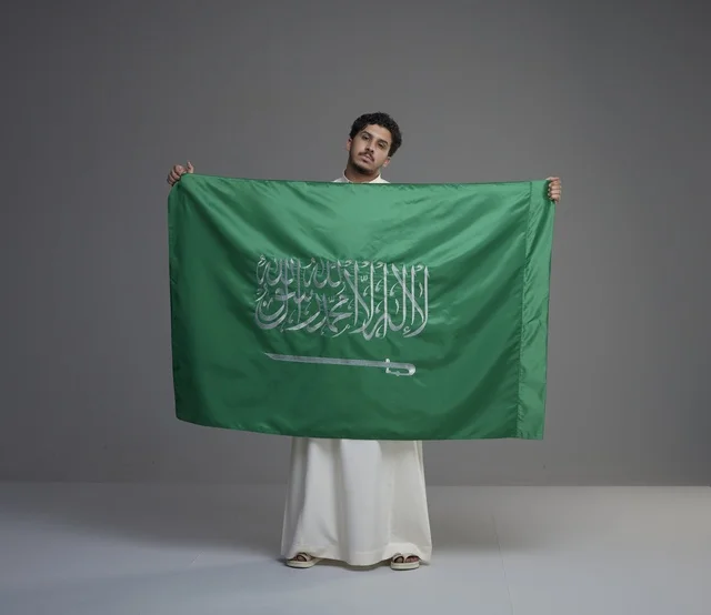 Saudi Man Holding National Flag in Studio