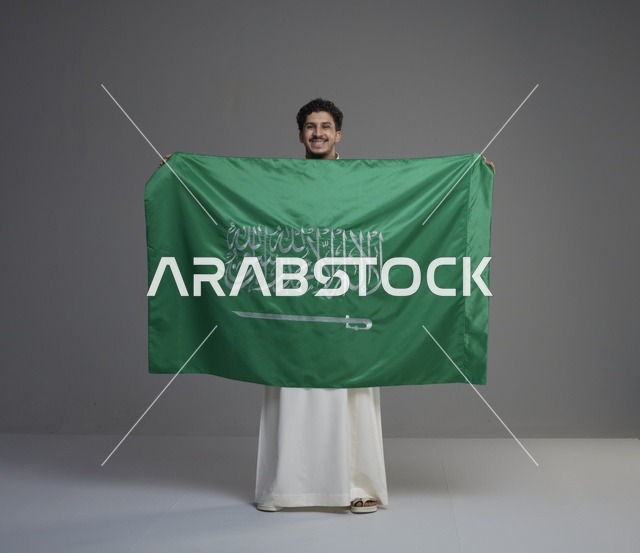 رجل سعودي يحمل علم المملكة العربية السعودية