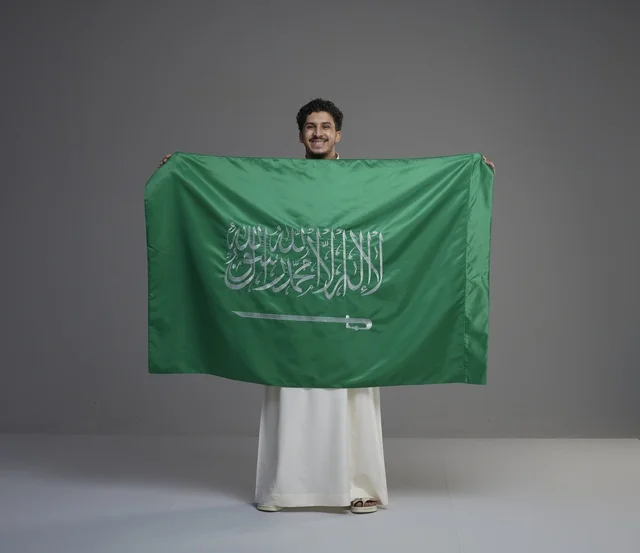 Saudi Man Holding Saudi Arabia Flag in Studio
