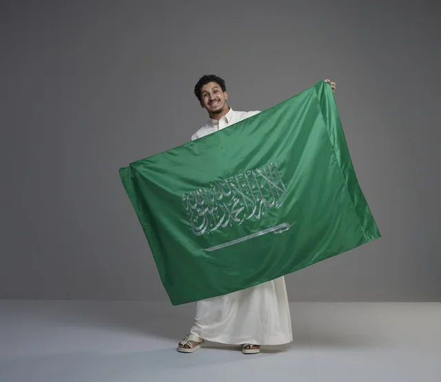 رجل سعودي يحمل علم المملكة العربية السعودية