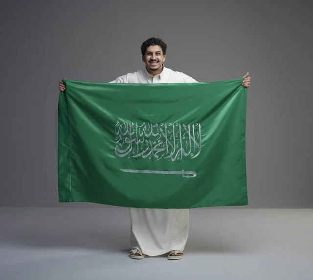 Saudi Man Holding Saudi Arabia Flag on Grey Background