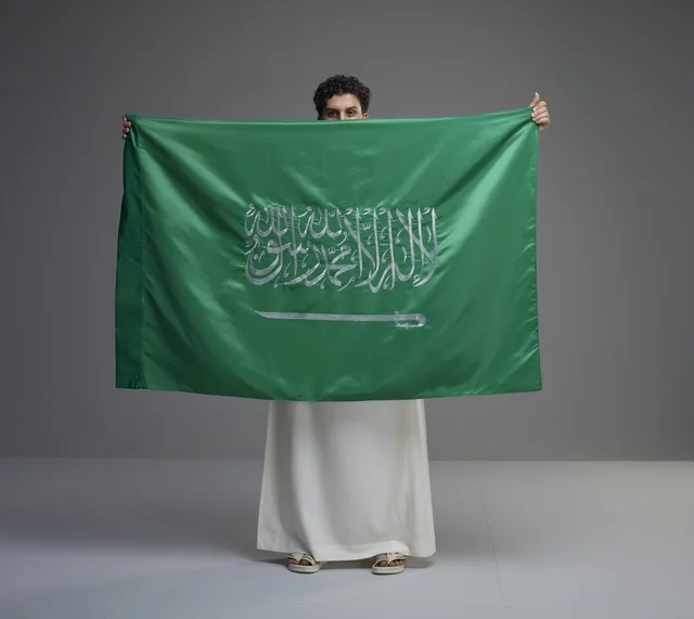 رجل سعودي يحمل علم المملكة العربية السعودية