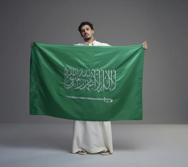 Saudi Man Holding Saudi Arabia Flag in Studio