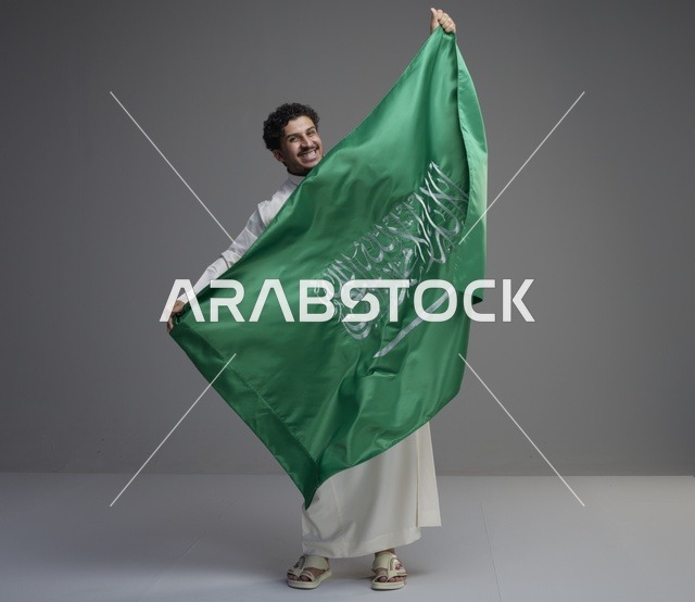 رجل سعودي يحمل علم المملكة العربية السعودية