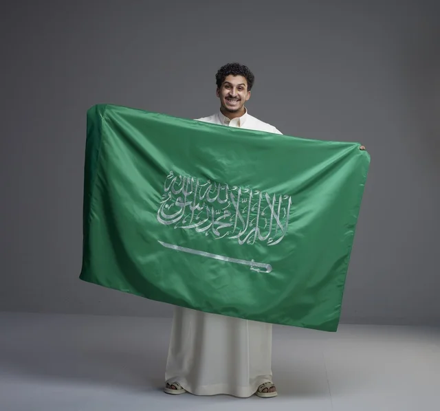 رجل سعودي يحمل العلم السعودي في الاستديو