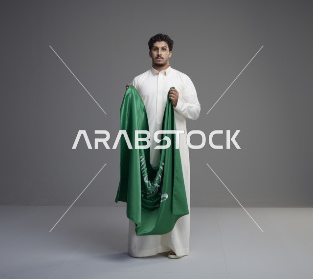 رجل سعودي يمسك علم المملكة العربية السعودية