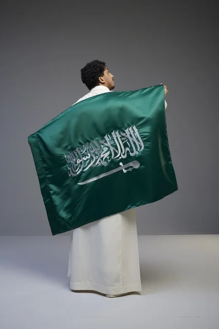 Saudi Man Holding Saudi Arabia National Flag in Studio