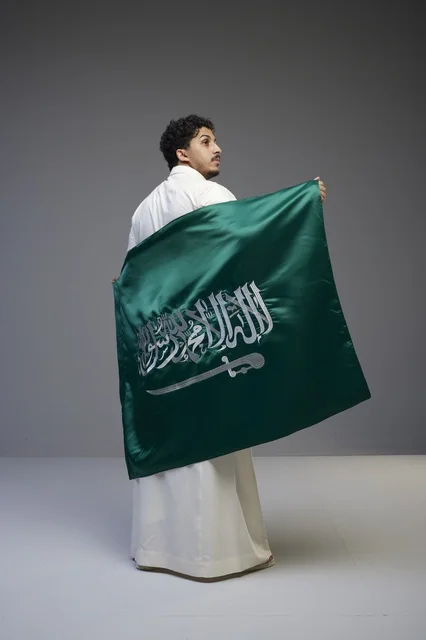 Saudi Man Holding Saudi Arabia Flag in Studio