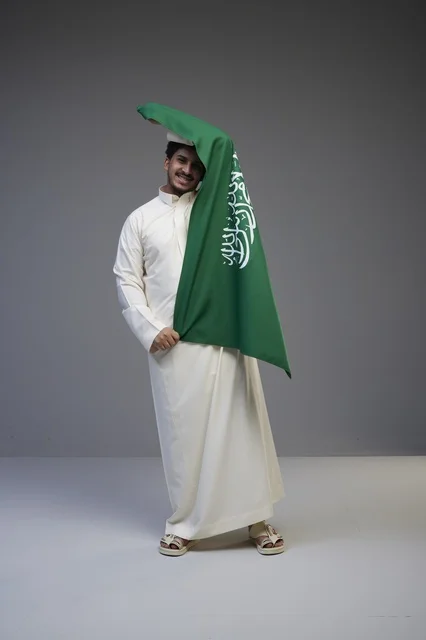 Saudi Man Holding National Flag in Studio Portrait