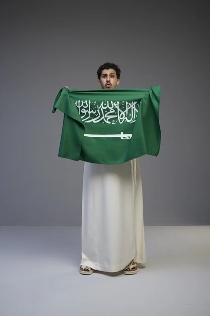 Saudi Man Holding Saudi Arabia Flag in Studio Portrait