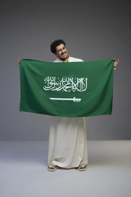 رجل سعودي يحمل علم المملكة العربية السعودية