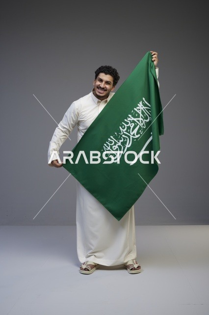 Saudi Man Holding Saudi Arabia Flag in Studio