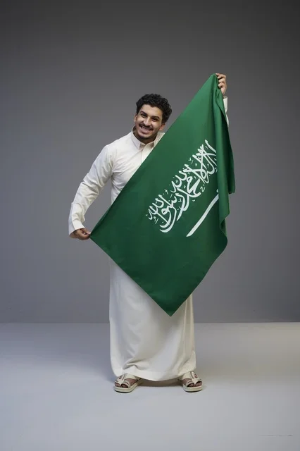 Saudi Man Holding Saudi Arabia Flag in Studio