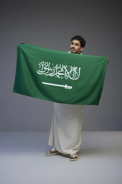 رجل سعودي يحمل العلم الوطني في الاستوديو