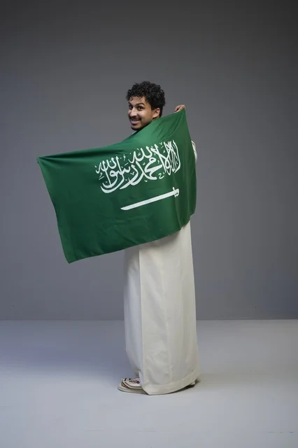 Saudi Man Holding National Flag in Studio Portrait