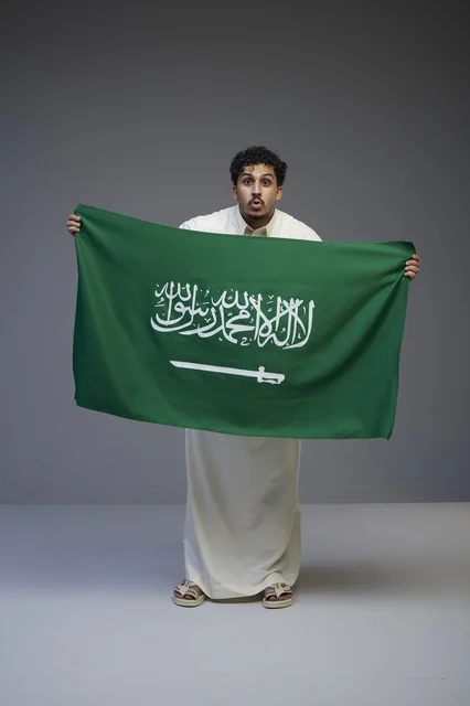 رجل سعودي يحمل العلم السعودي في الاستوديو
