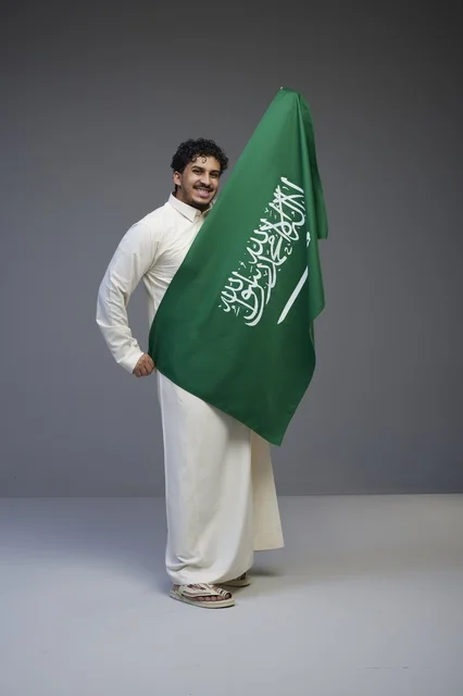 Saudi Man Holding National Flag in Studio