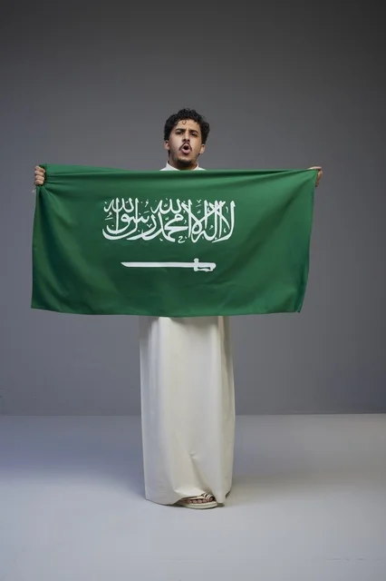Saudi Man Holding National Flag in Studio