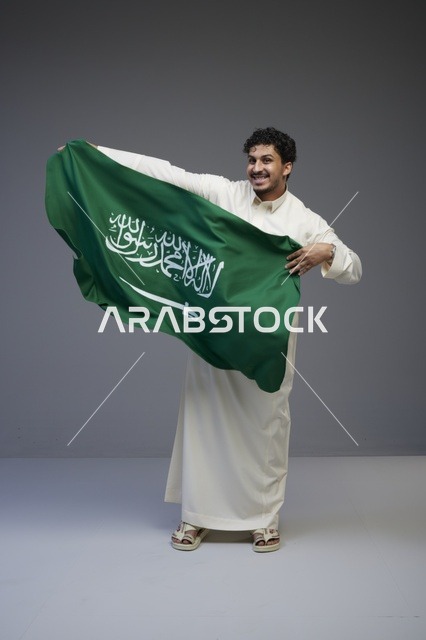 رجل سعودي يحمل علم المملكة العربية السعودية
