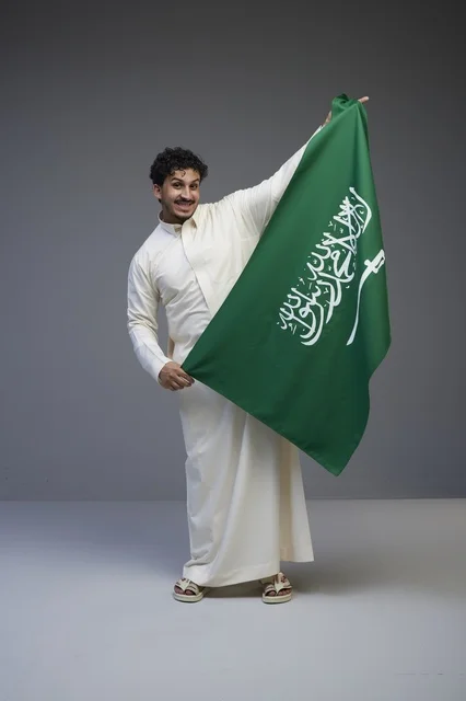 Saudi Man Holding National Flag in Studio Portrait