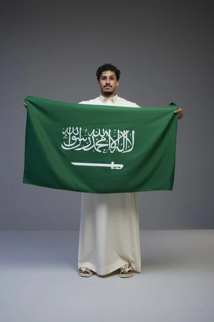 Saudi Man Holding Saudi Arabia National Flag in Studio