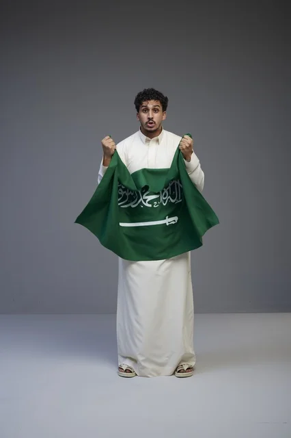 رجل سعودي يحمل علم المملكة العربية السعودية