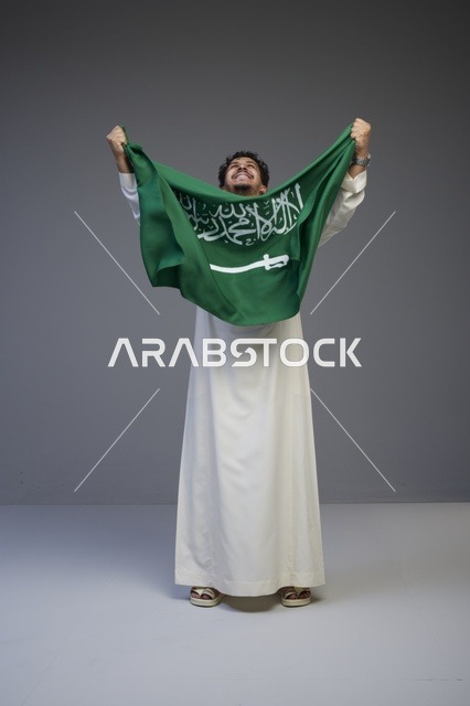 رجل سعودي يحمل علم المملكة العربية السعودية