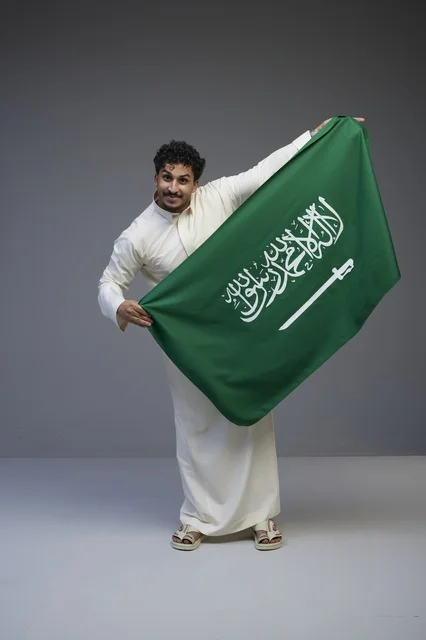 Saudi Man Holding Saudi National Flag in Studio