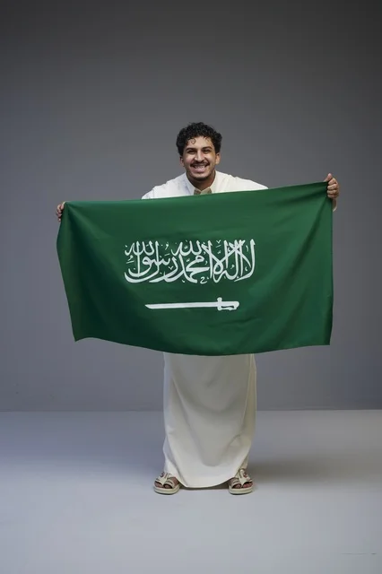 رجل سعودي يحمل العلم السعودي في الاستوديو