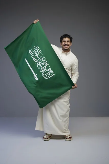 Saudi Man Holding Saudi National Flag in Studio