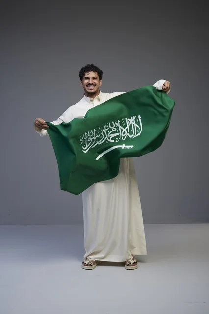 Saudi Man Holding Saudi Arabia Flag in Studio