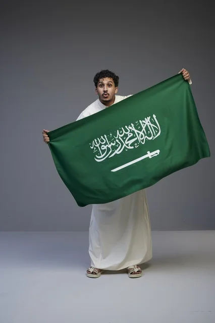 Saudi Man Holding National Flag in Studio