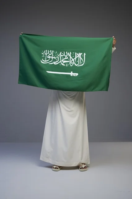 Saudi Man Holding National Flag in Studio Portrait