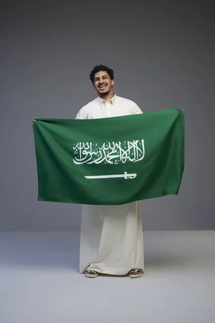 Saudi Man Holding National Flag in Studio